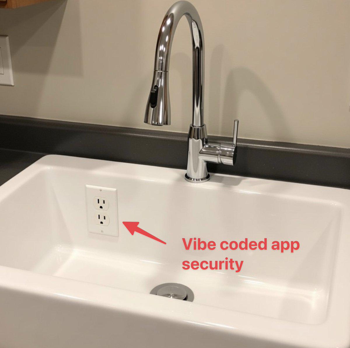 A white kitchen sink with an electrical wall socket fitted inside the basin, below the tap. A red arrow labels the socket 'Vibe coded app security'.